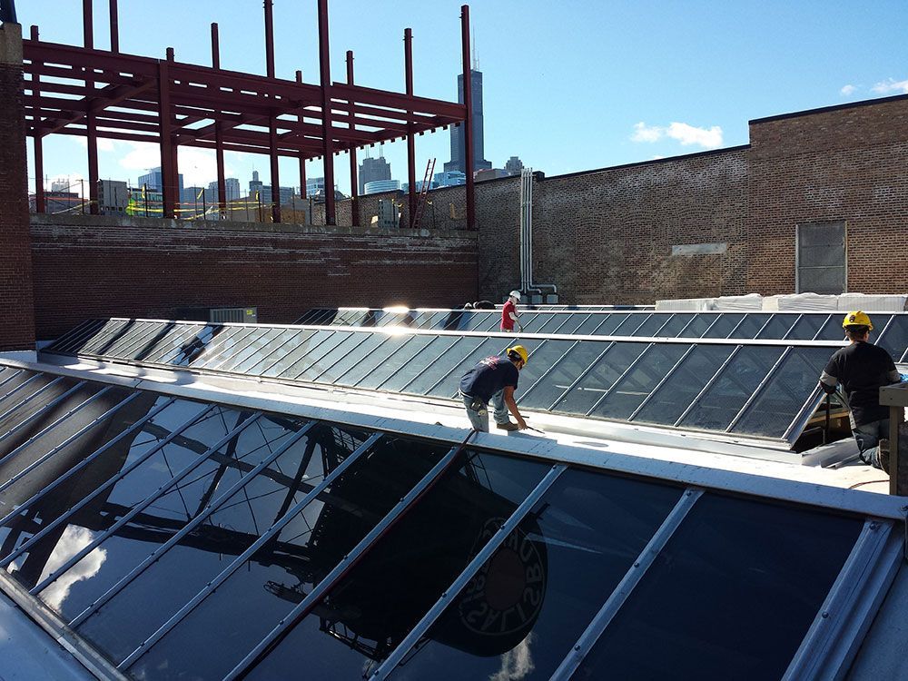 Two men are working on the roof of a building
