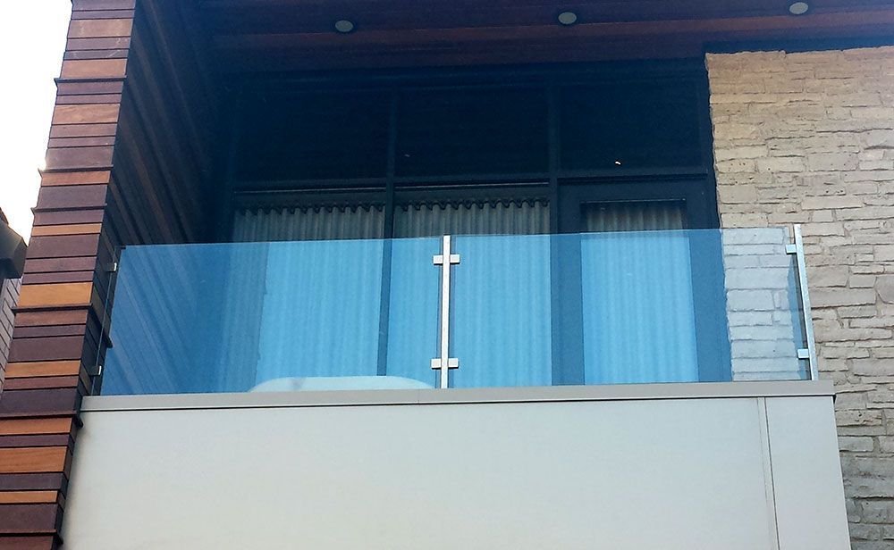 A balcony with a glass railing on the side of a building
