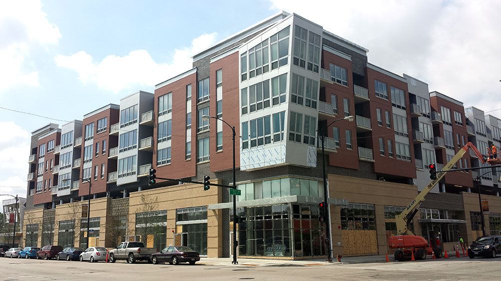 A large building with a lot of windows and cars parked in front of it