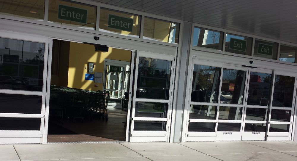 A store front with sliding glass doors and a sign that says enter