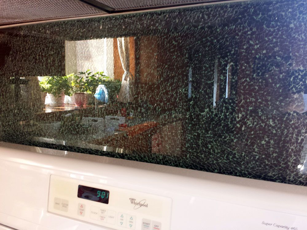 A white whirlpool stove with a reflection of a kitchen in the glass