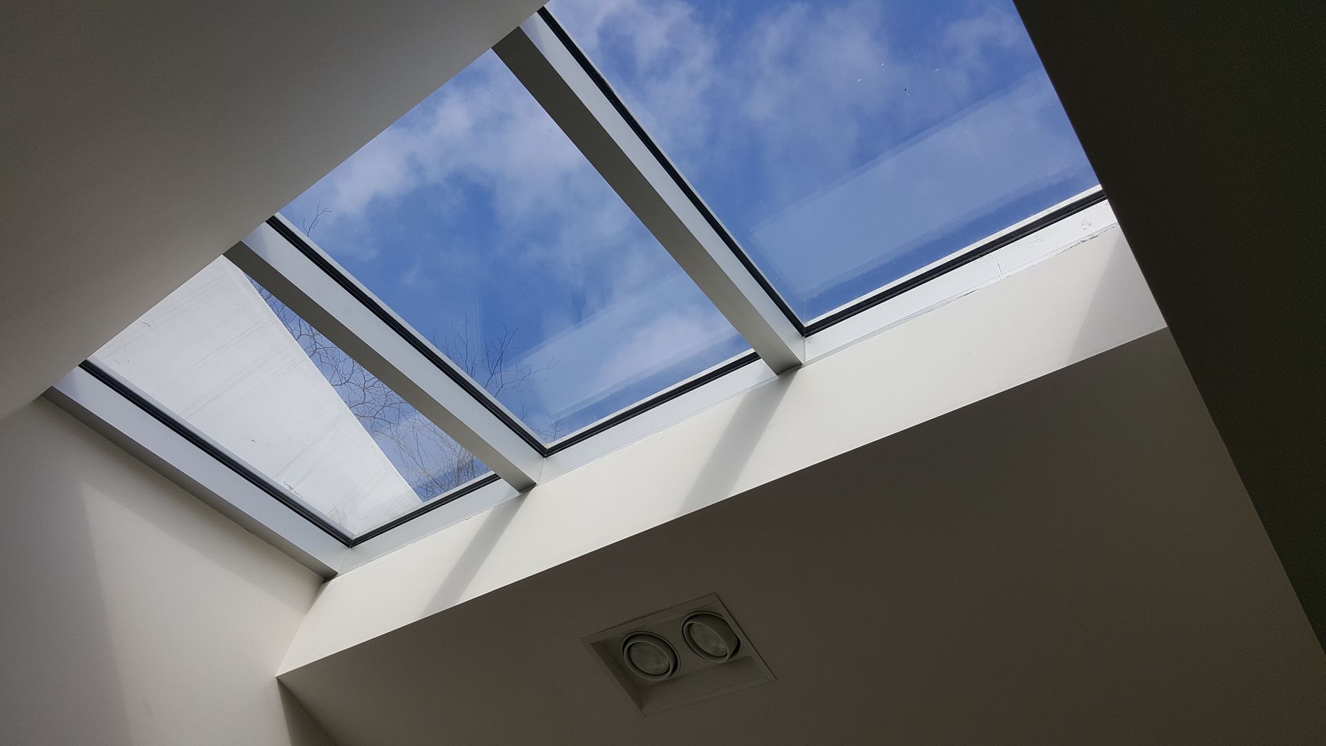 Looking up at a skylight with a blue sky in the background