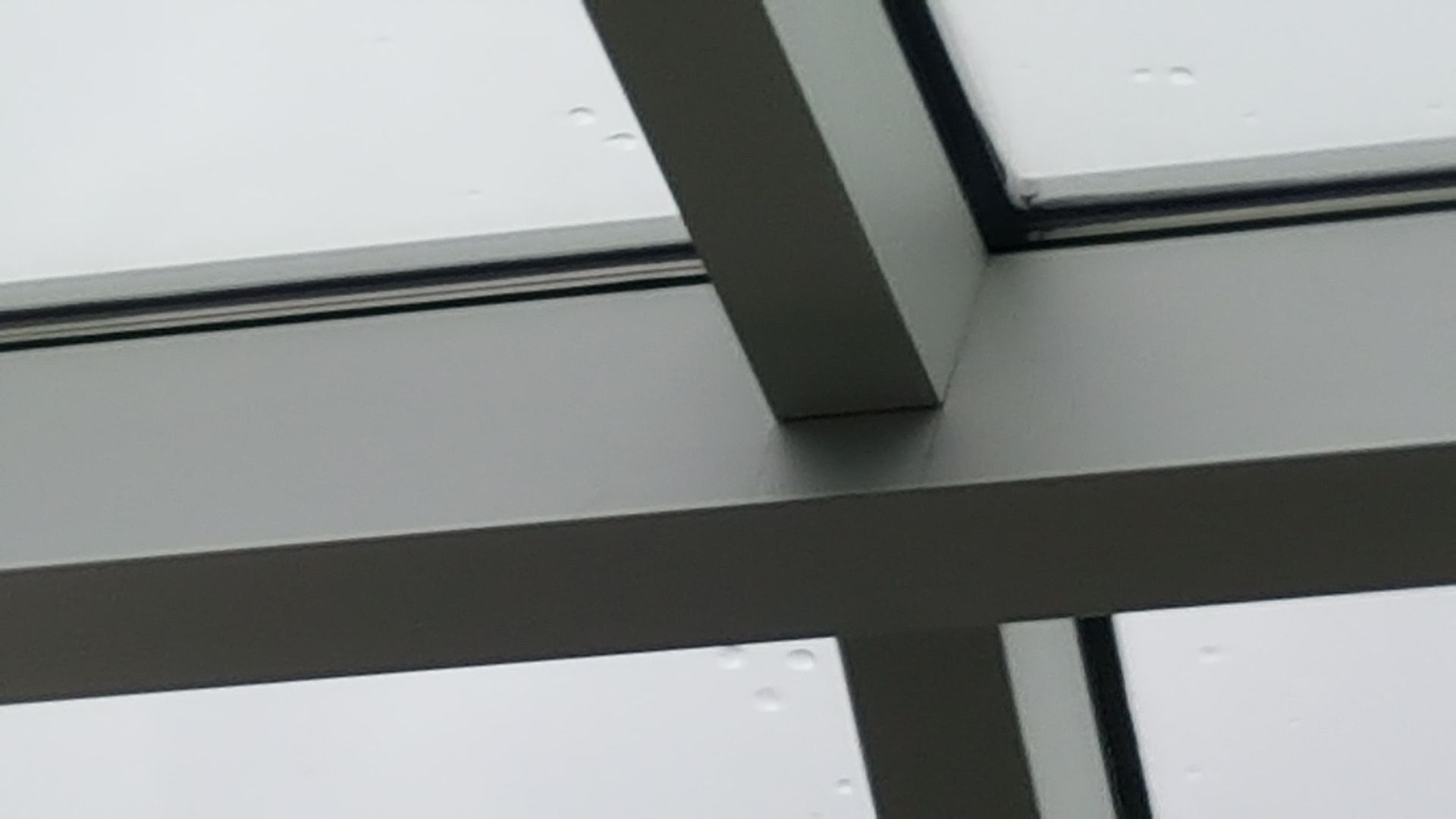 A close up of a metal structure with a glass roof