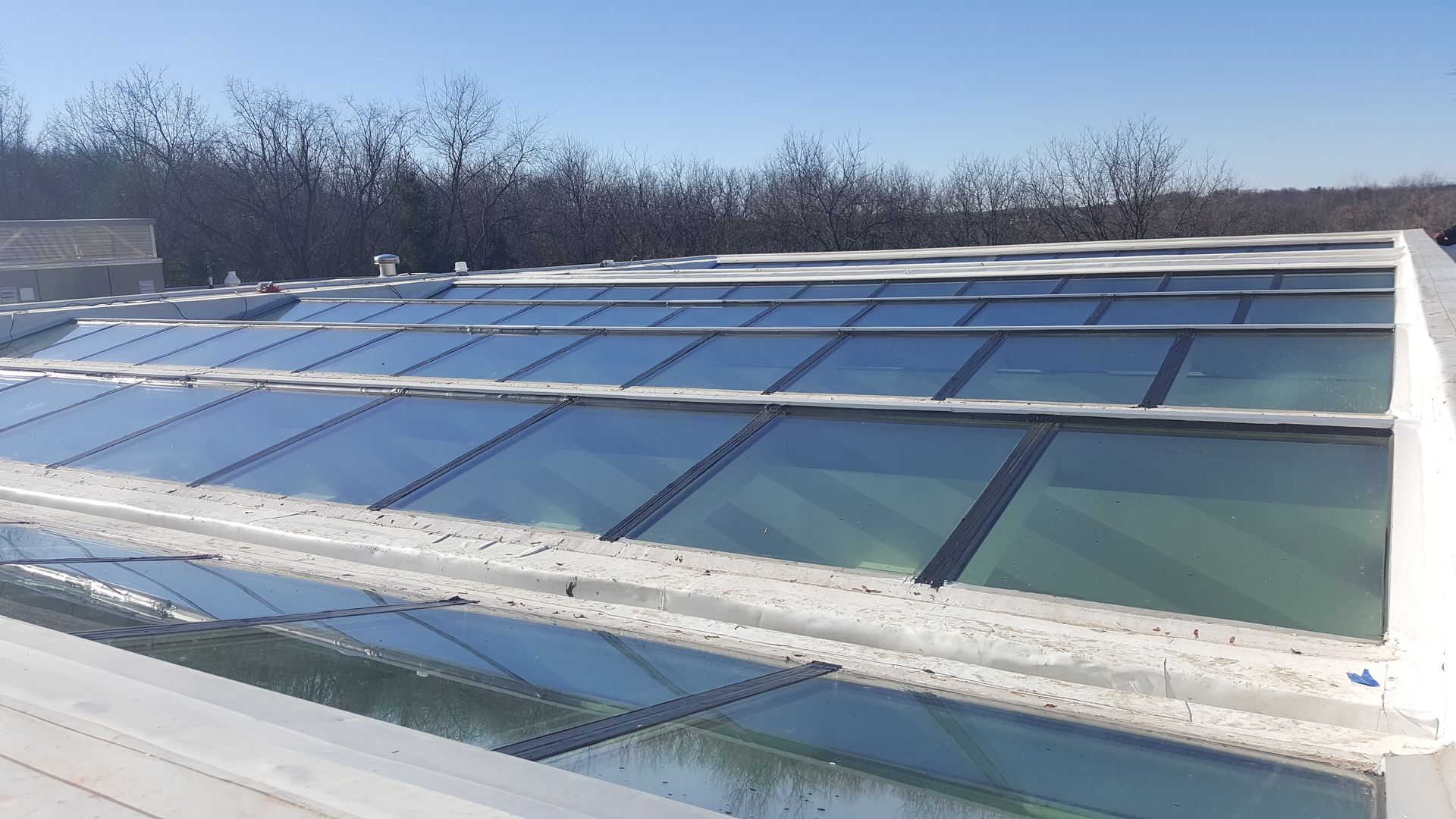 A roof with a lot of windows and a blue sky in the background.