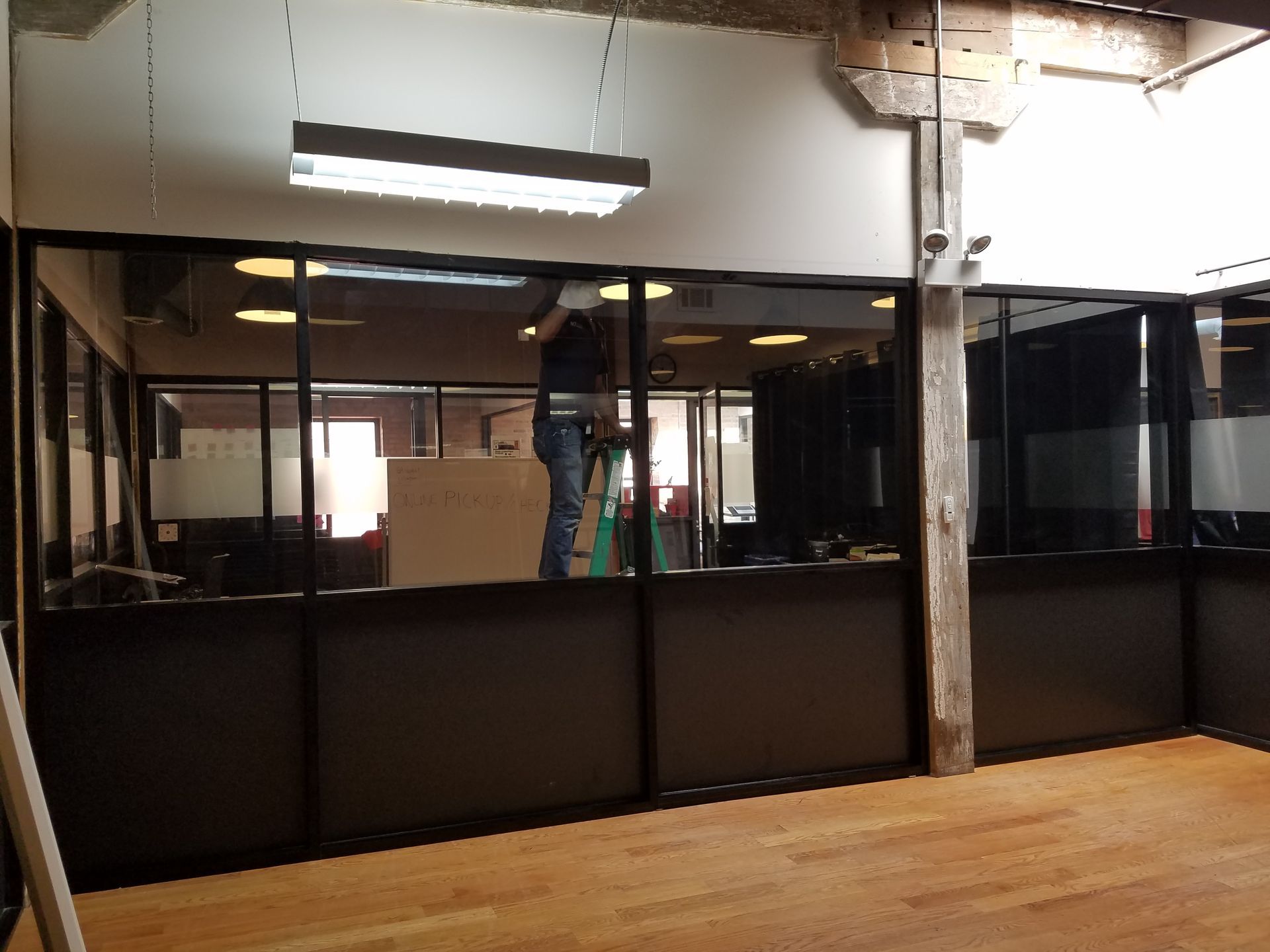A man is standing in a room with a lot of windows.