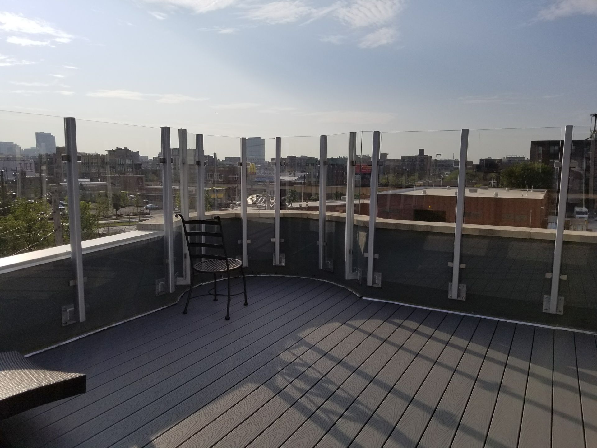 A chair sits on a balcony overlooking a city