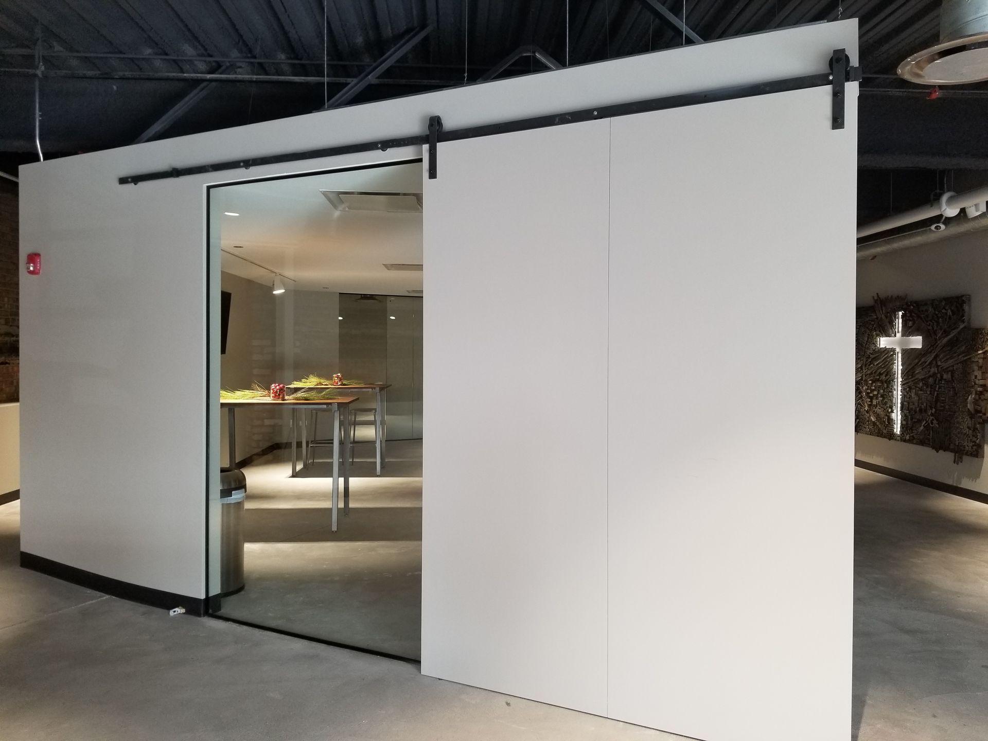 A room with a sliding glass door and a cross on the wall