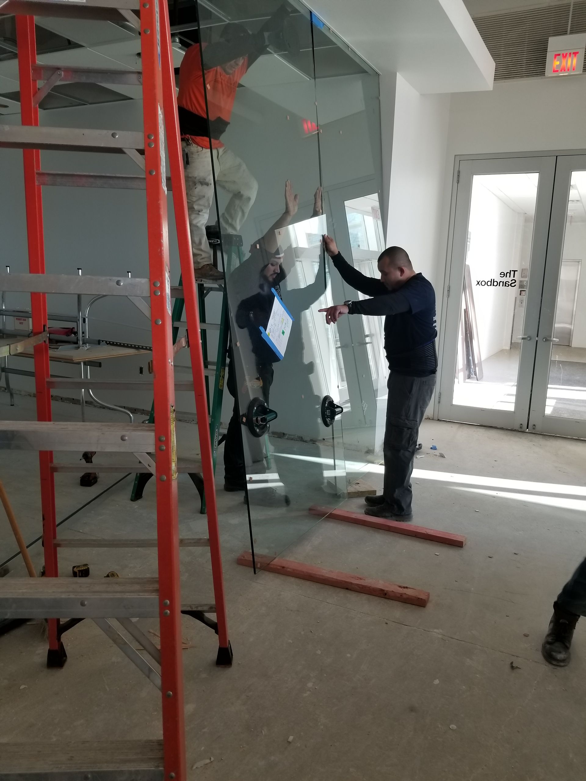 A man is standing in a room holding a piece of glass