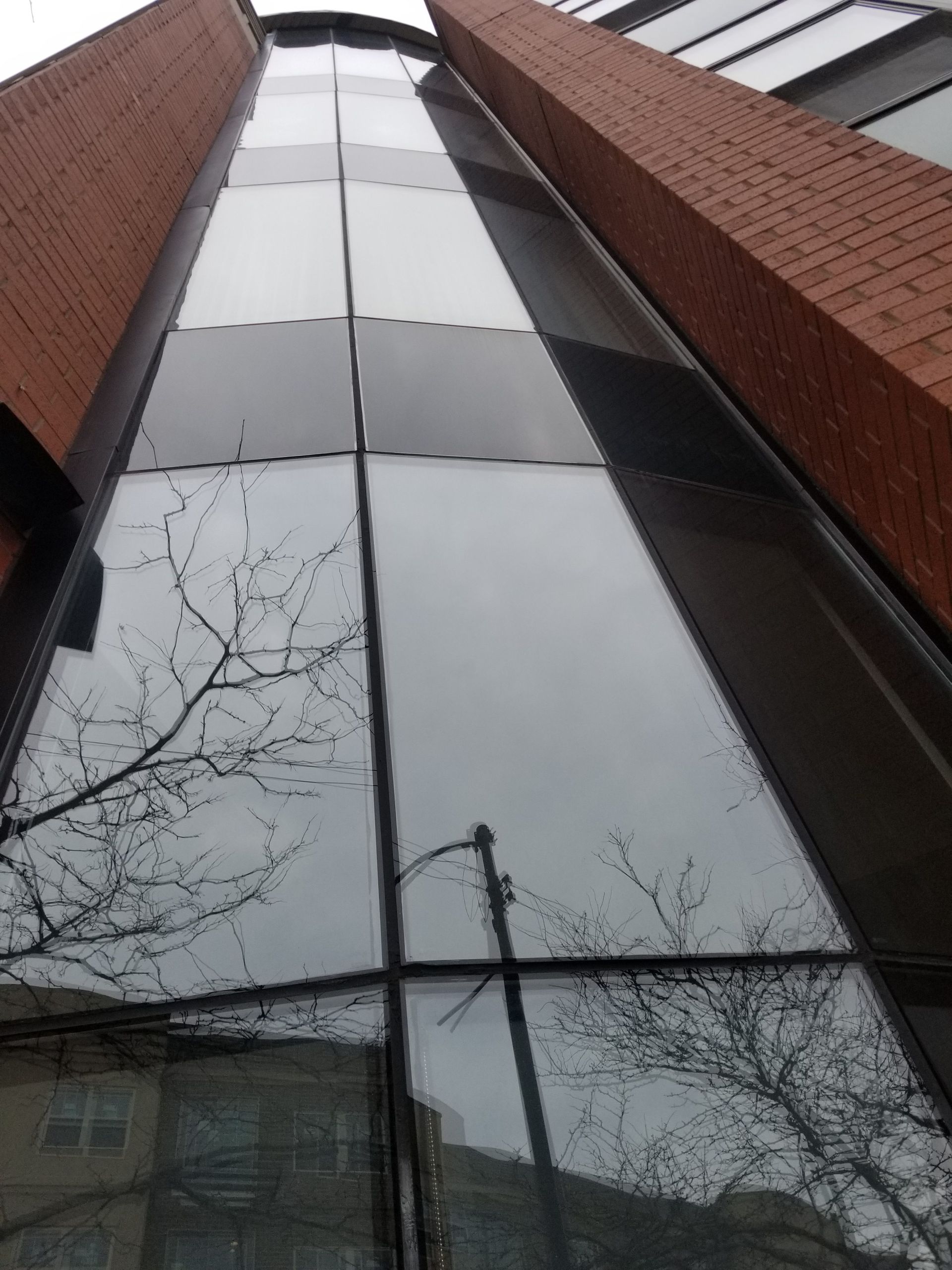 A tall building with a brick facade and a glass facade