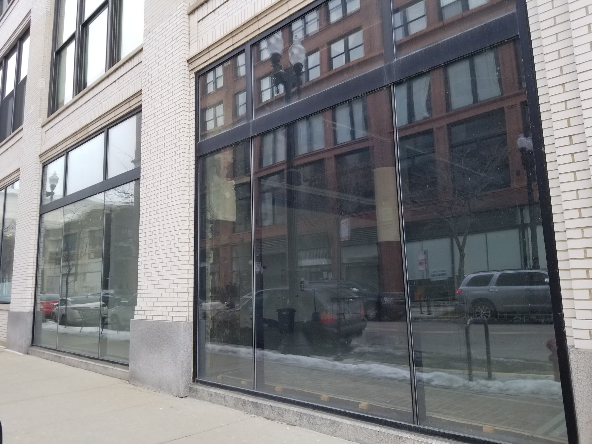 A building with a lot of windows and a car parked in front of it