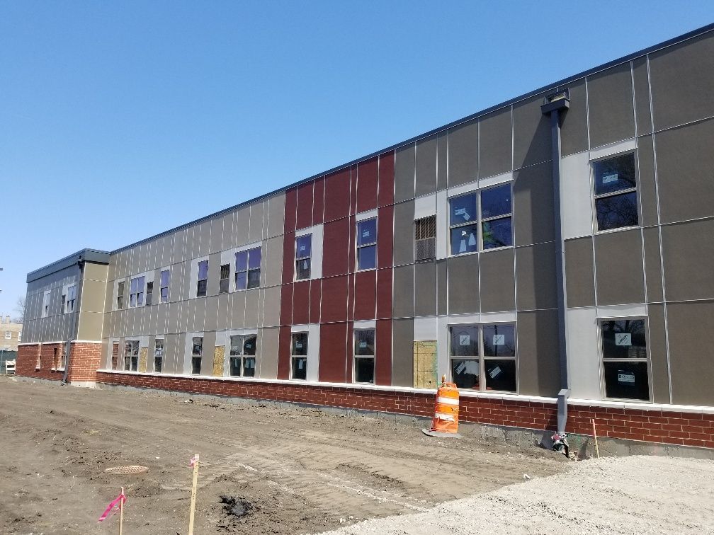 A large building with a lot of windows is under construction.