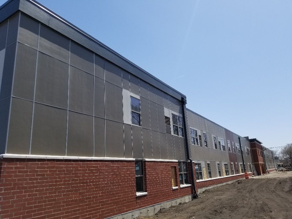 A large brick building with a lot of windows and a roof