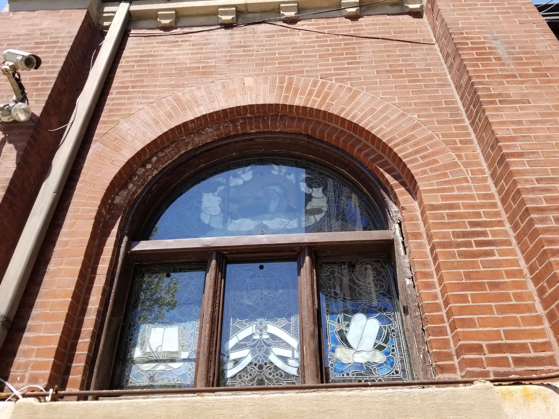 A brick building with a large arched window