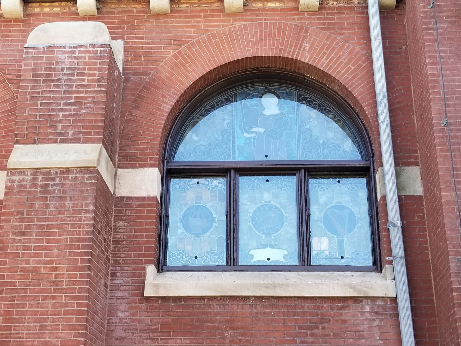 A brick building with a large arched window