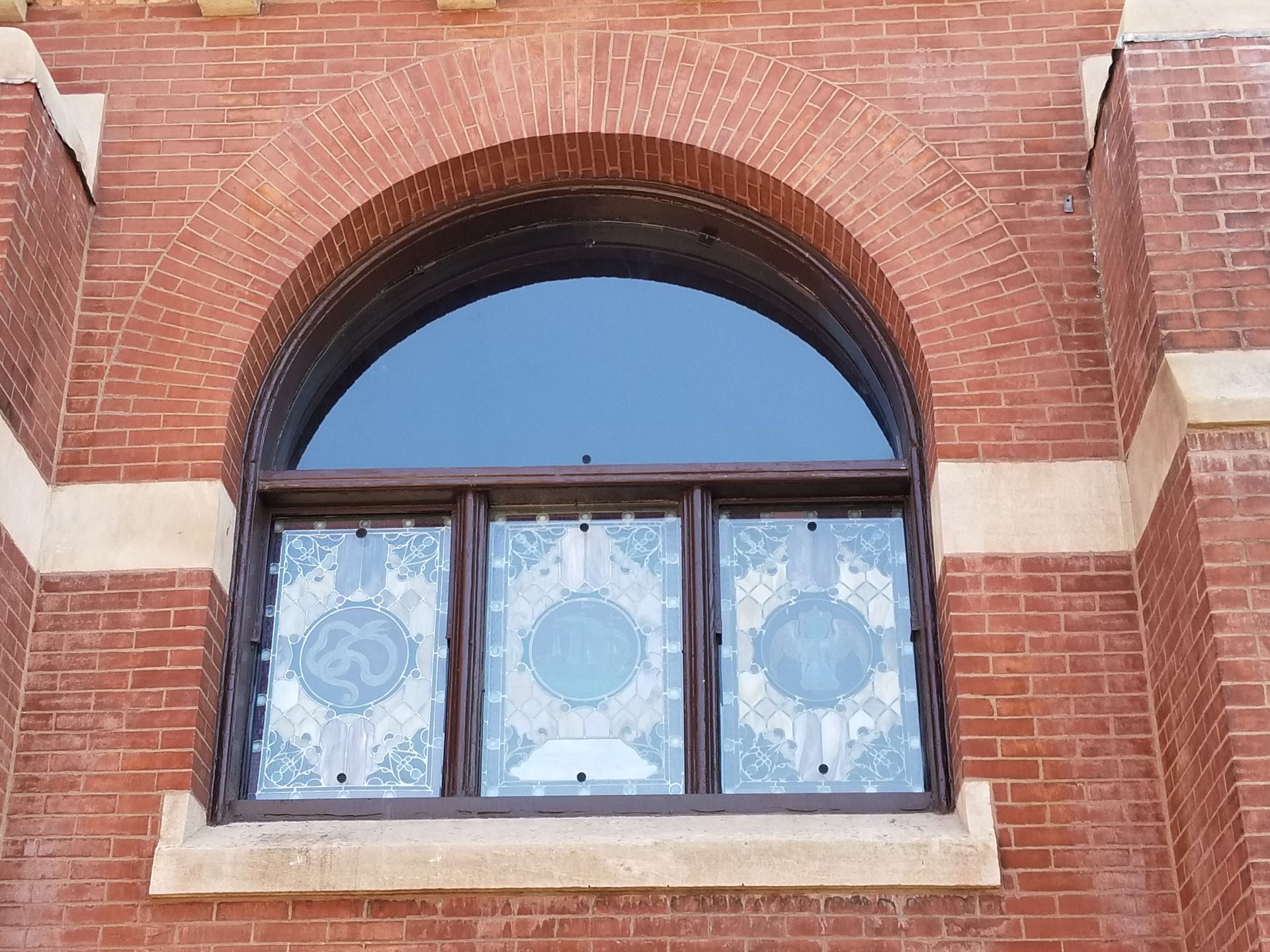 A brick building with a large arched window