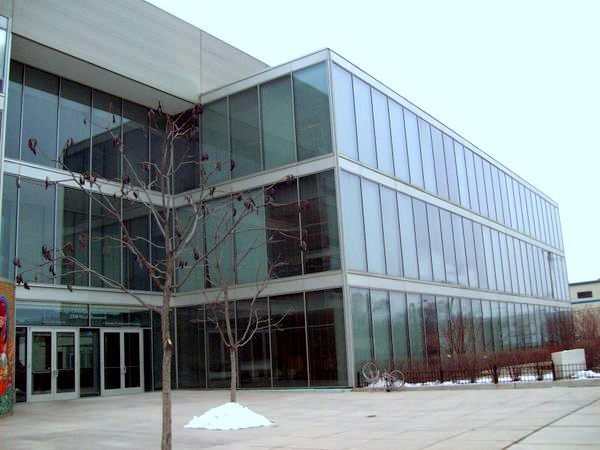A large building with a lot of windows and a tree in front of it