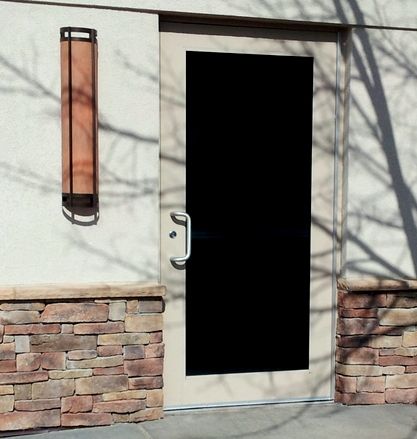 A building with a black door and a brick wall