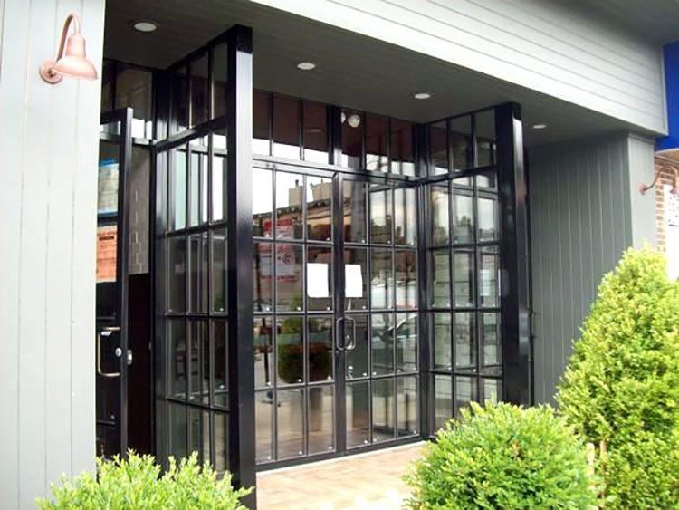 A building with a lot of windows and bushes in front of it