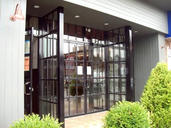 A building with a lot of windows and bushes in front of it