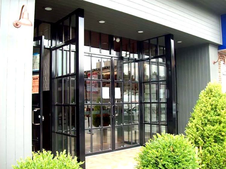 A building with a lot of windows and bushes in front of it
