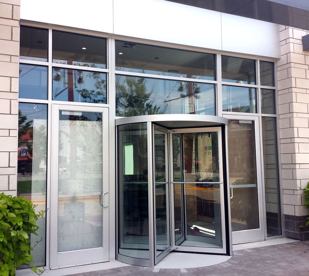A building with a revolving door and lots of windows