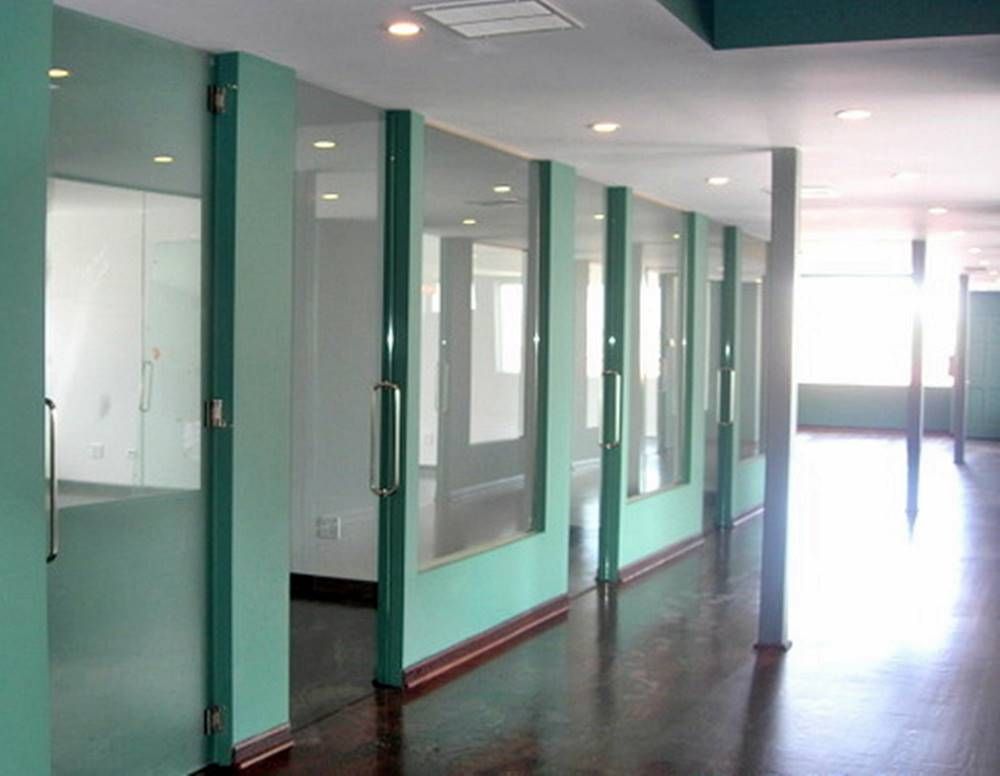 A long hallway with green walls and glass doors