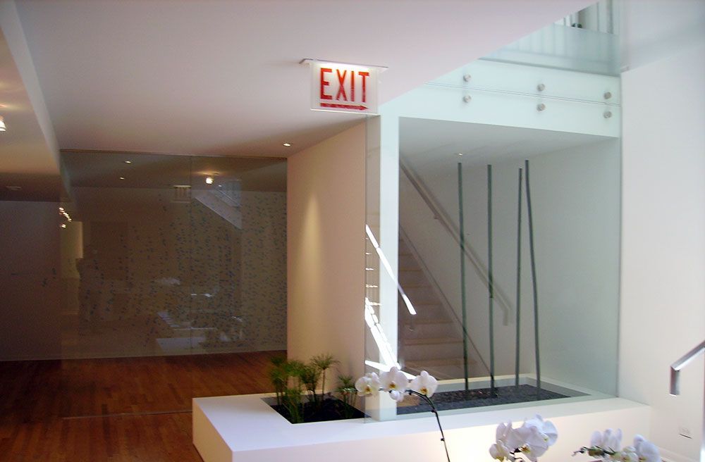 A red exit sign hangs from the ceiling of a room