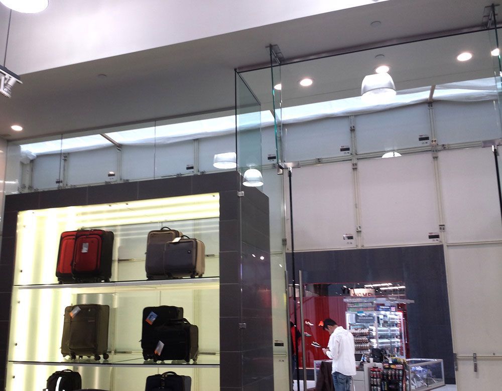 A man in a white shirt stands in front of a display of luggage