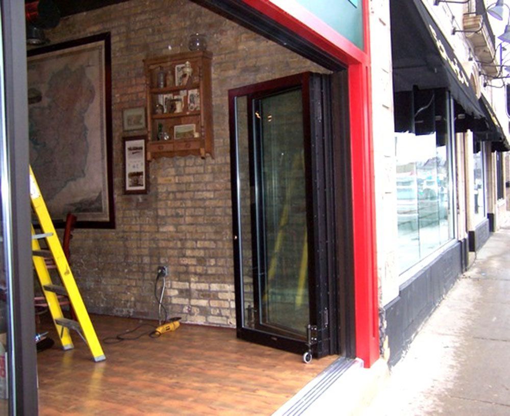 A yellow ladder sits in front of a brick building