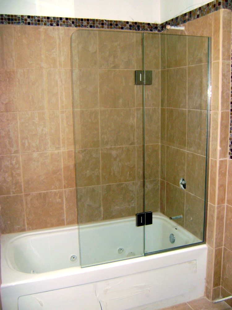 A bathtub in a bathroom with a glass shower door
