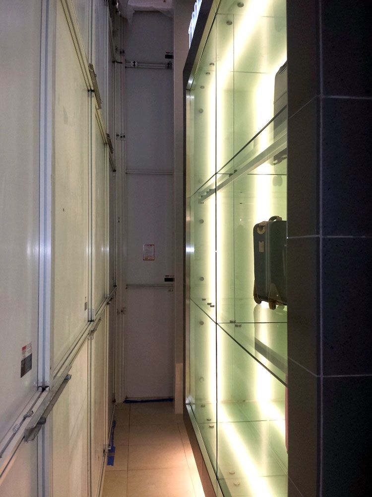 A long hallway with a suitcase on a shelf