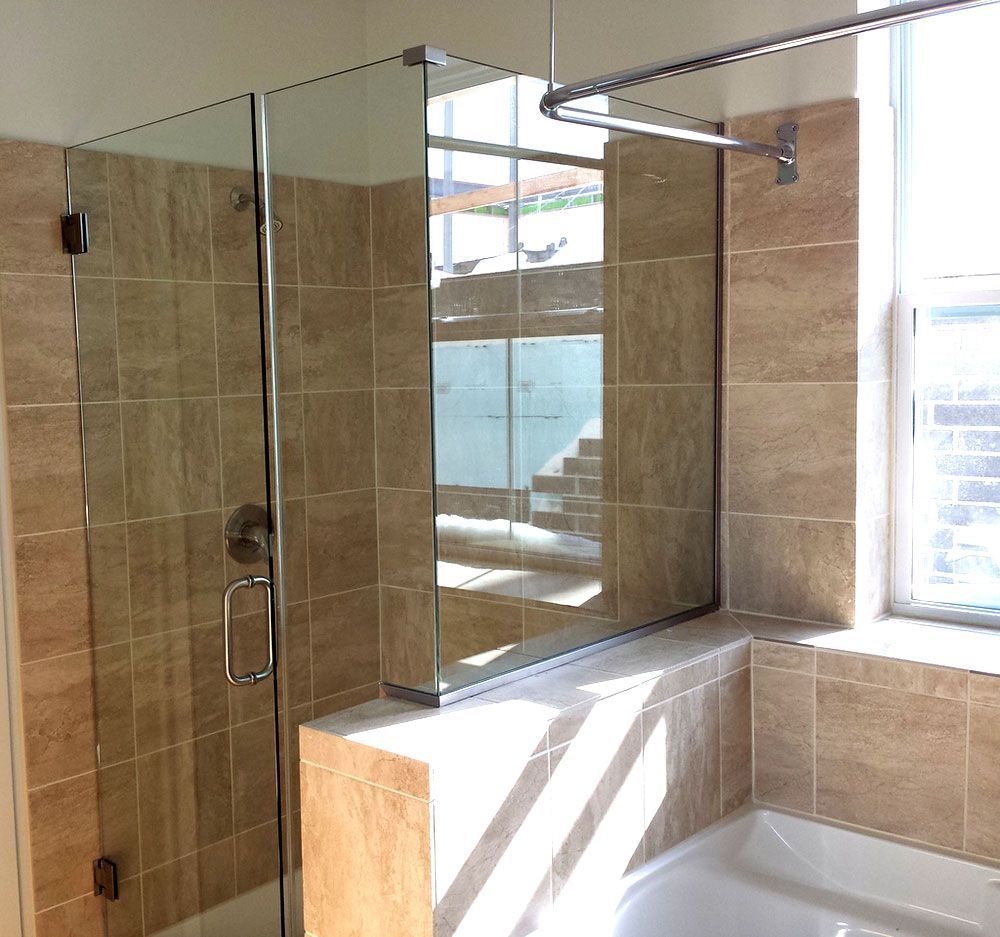 A bathroom with a tub and a shower with a glass door