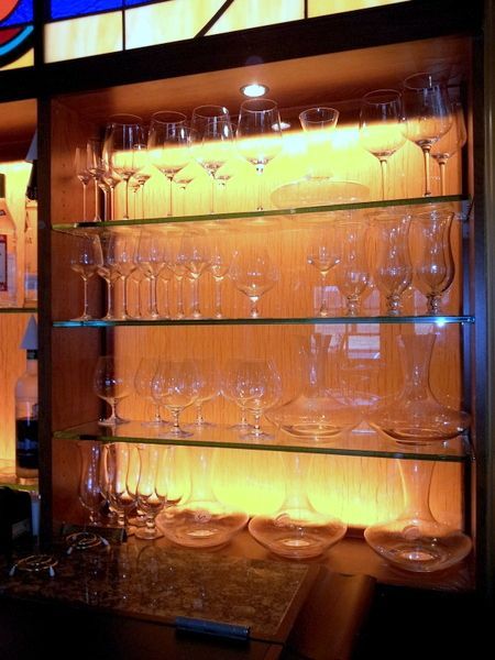 A shelf filled with wine glasses and plates