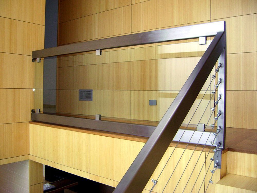 A staircase with a stainless steel railing and a glass railing