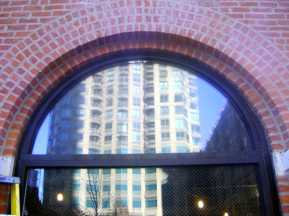 A building is reflected in a window of a brick building