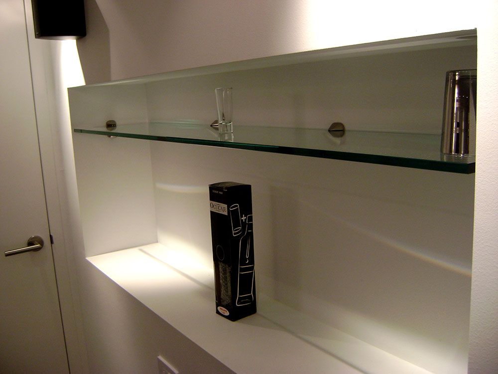 A shelf with glass shelves and a box on it