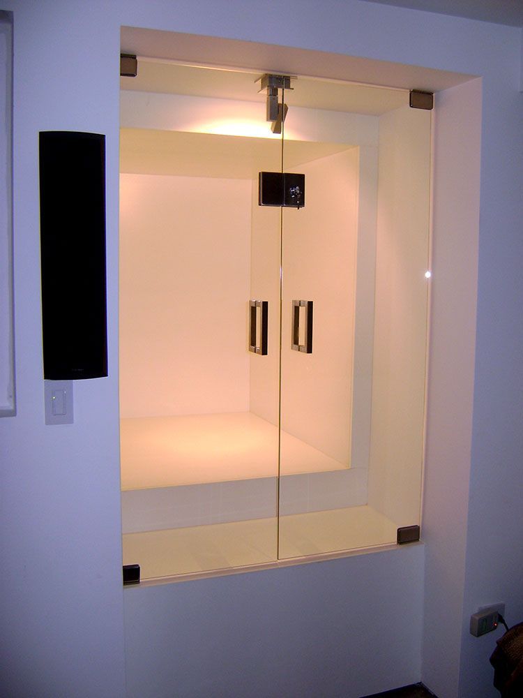 A room with a glass door and a speaker on the wall