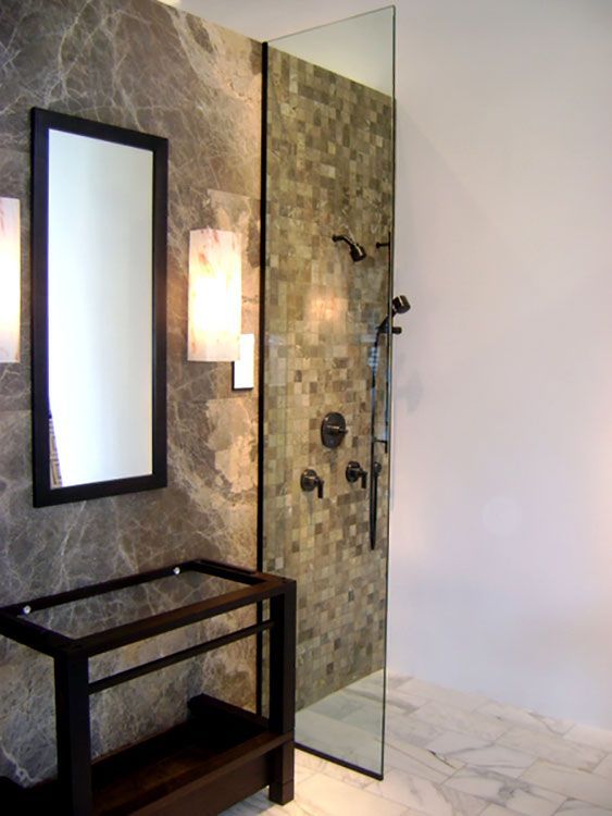 A bathroom with a walk in shower and a mirror