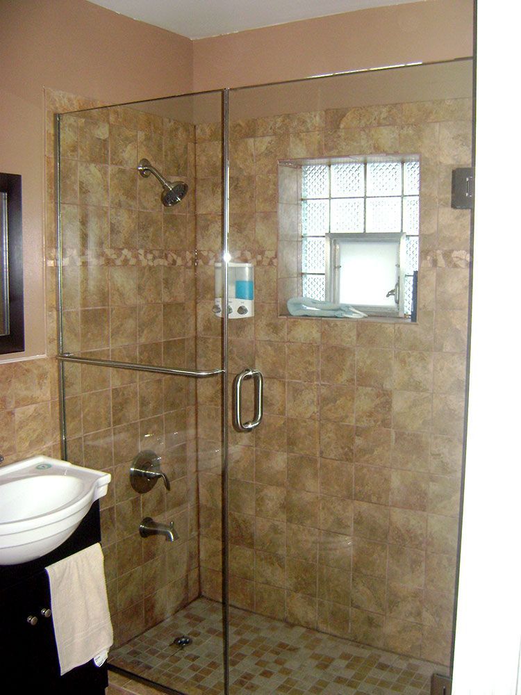 A bathroom with a walk in shower and a sink