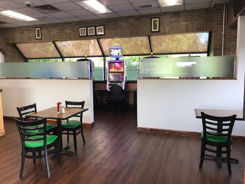 A restaurant with tables and chairs and a slot machine