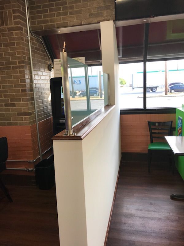 A restaurant with tables and chairs and a brick wall