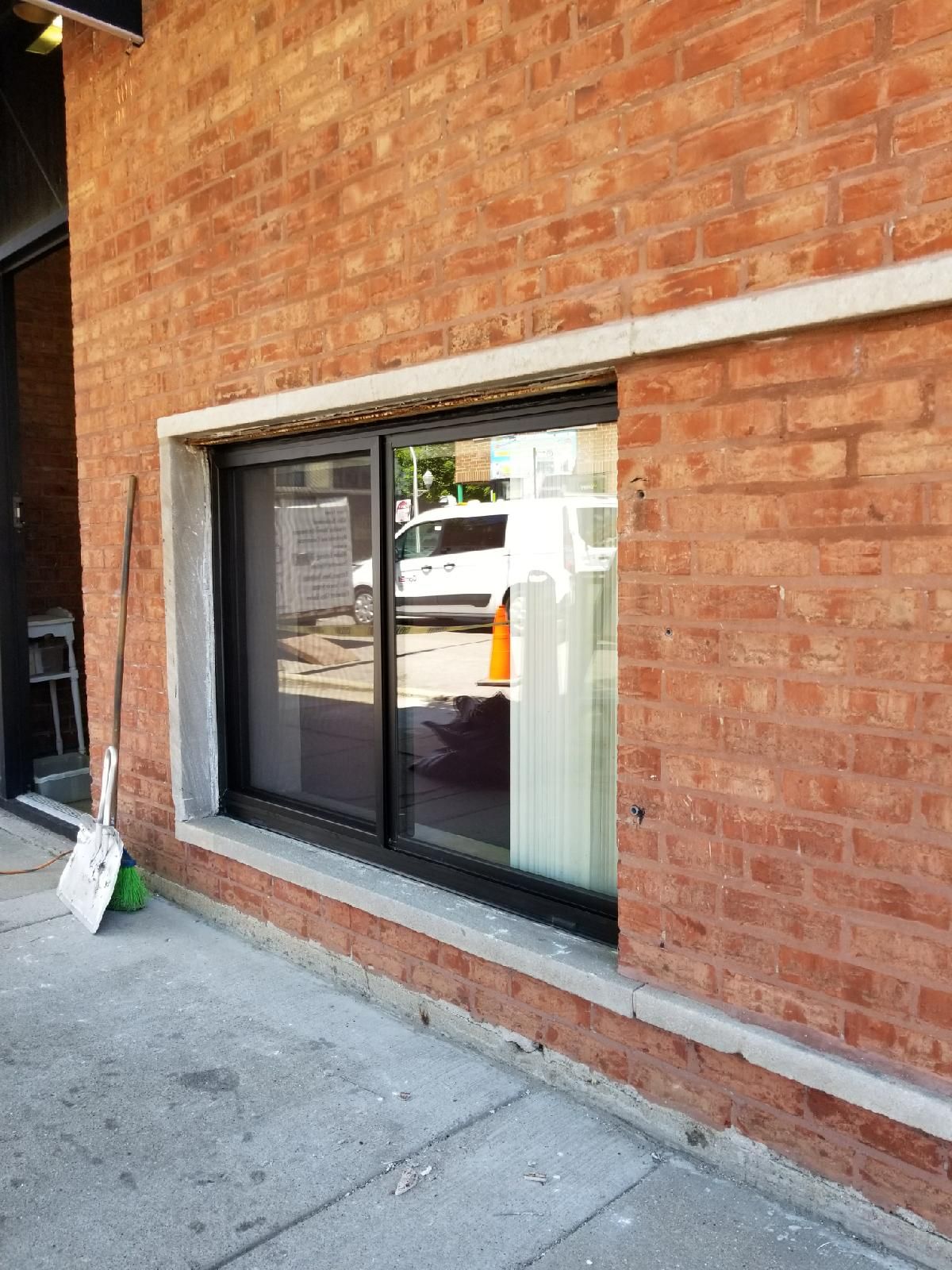 A brick building with a sliding glass door and a window.