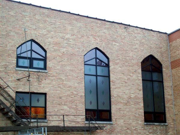 A brick building with arched windows and a fire escape