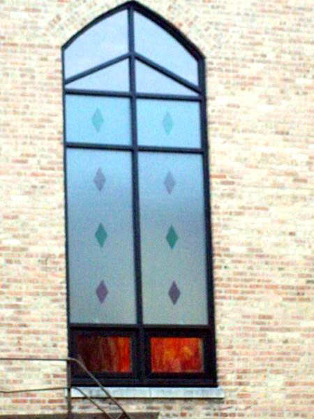 A stained glass window on a brick building