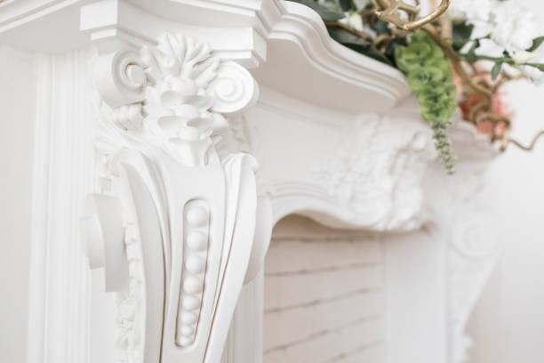 White ornate fireplace mantel with decorative carvings and flowers.