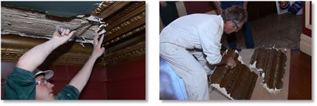 Two people are examining damaged plaster, possibly removing it. One person works on the ceiling, while the other works on the floor.