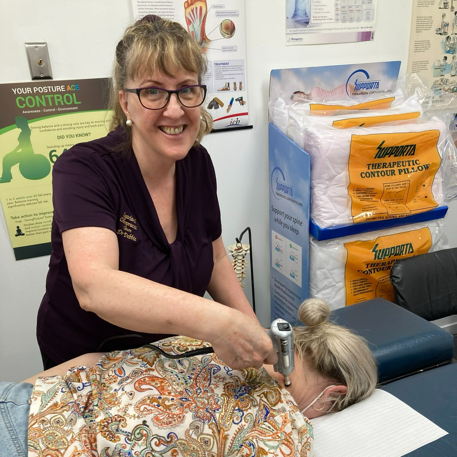 A Woman is Examining a Man 's Back While He Sits on a Table — Sugarland Chiropractic Centre in Avoca, QLD