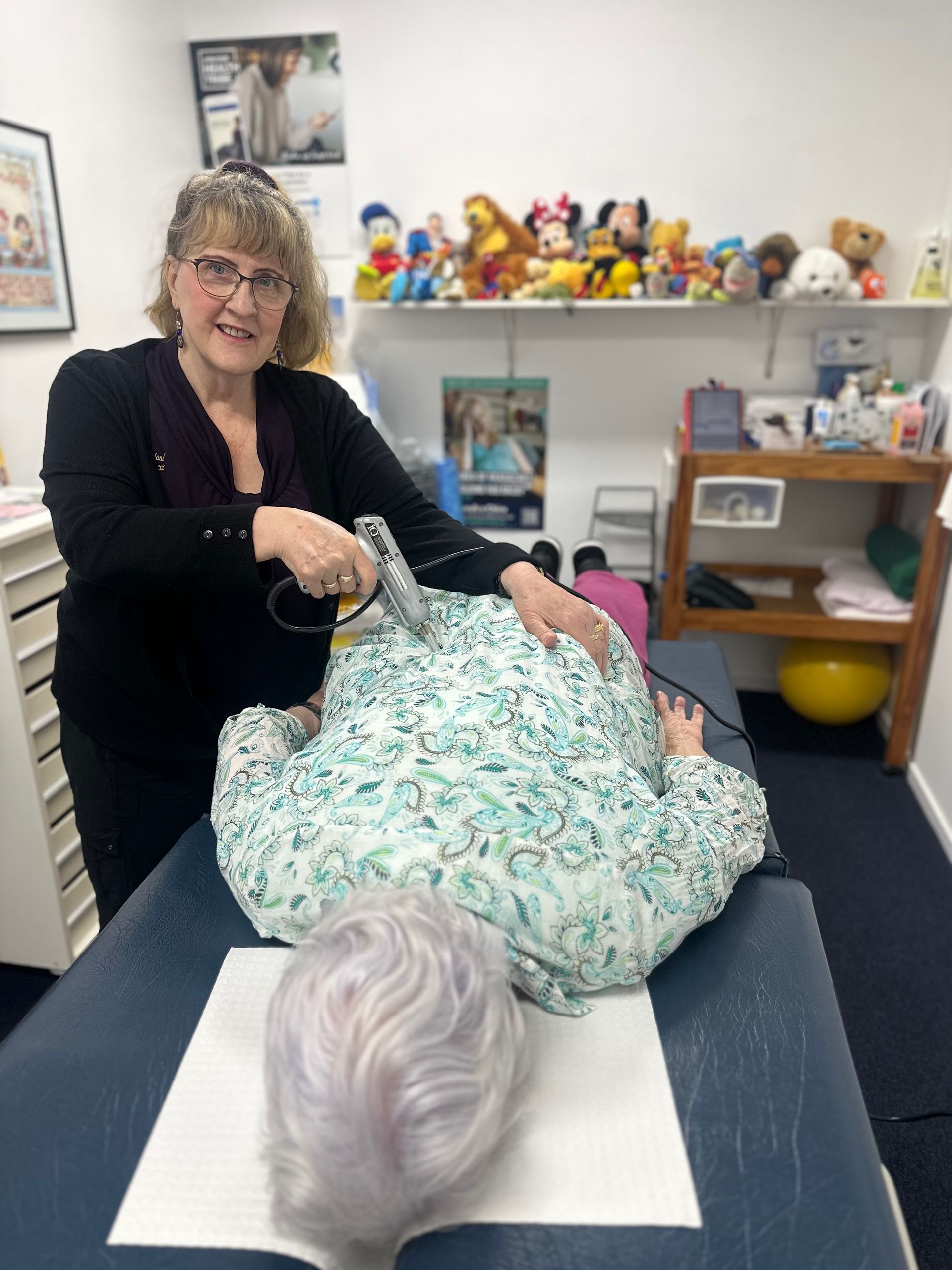 A Woman is Giving a Man a Massage on a Table — Sugarland Chiropractic Centre in Avoca, QLD