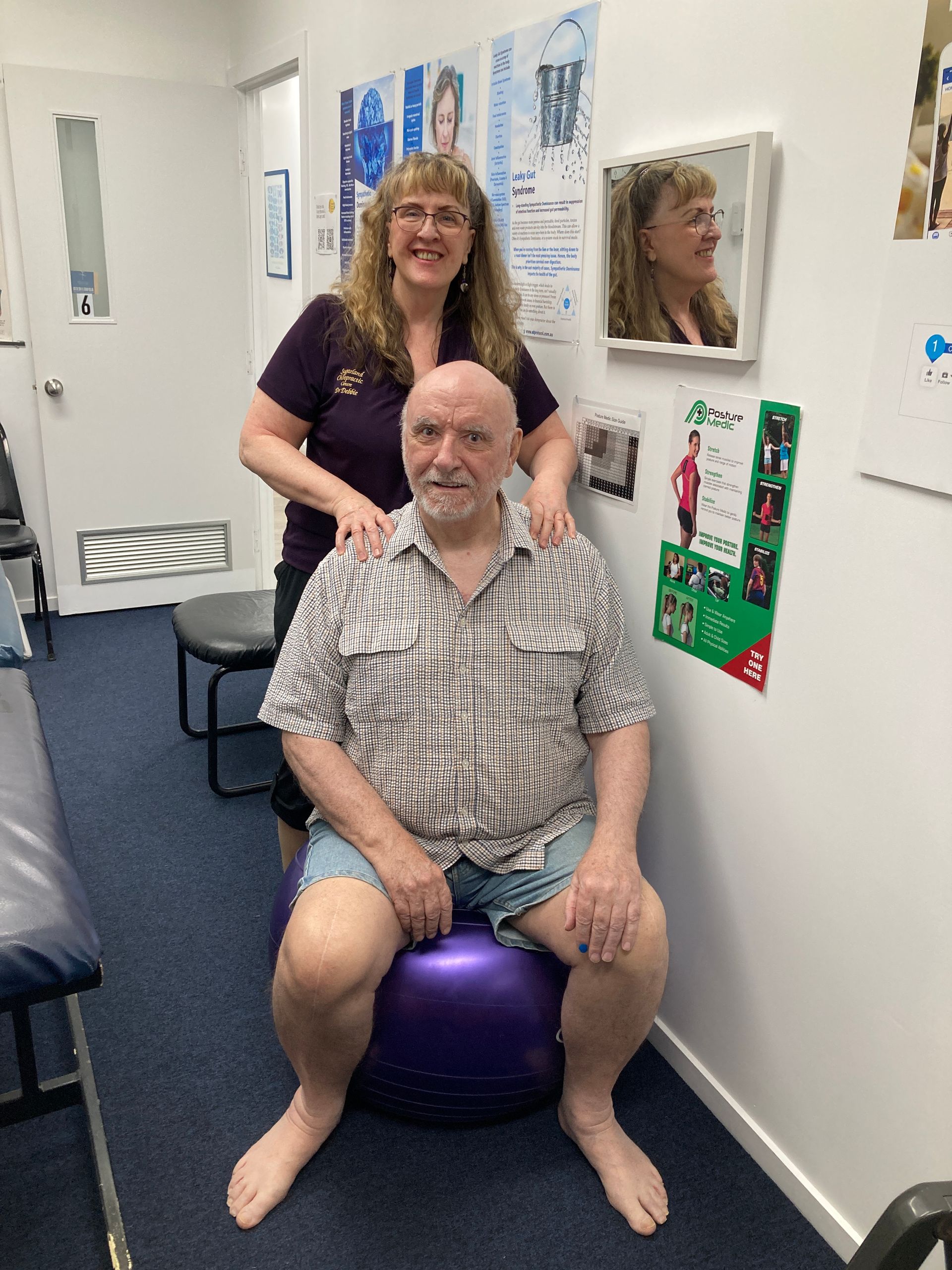 A Doctor is Helping an Elderly Man Stretch His Arms — Sugarland Chiropractic Centre in Avoca, QLD