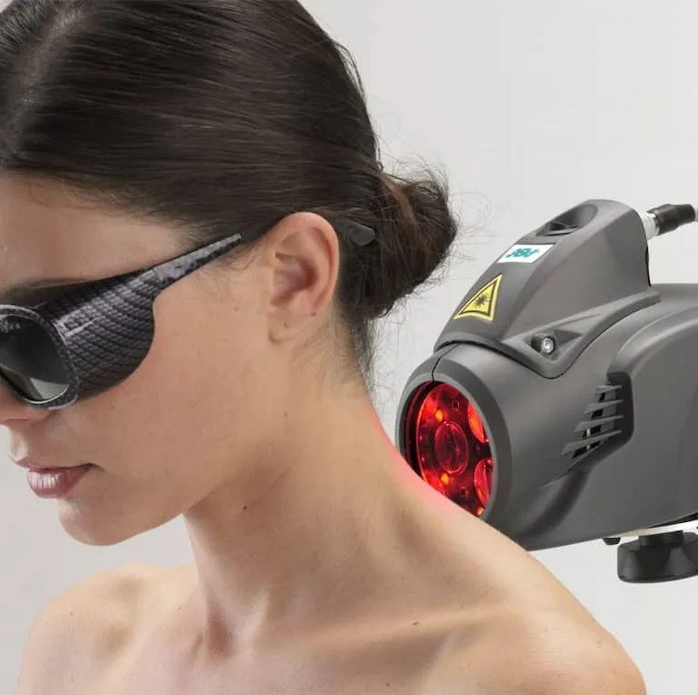 A Woman Wearing Sunglasses Has a Red Light on Her Neck — Sugarland Chiropractic Centre in Avoca, QLD